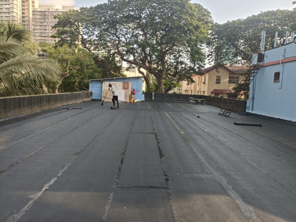 Vihaan Enterprises team applying professional waterproofing coating on a terrace